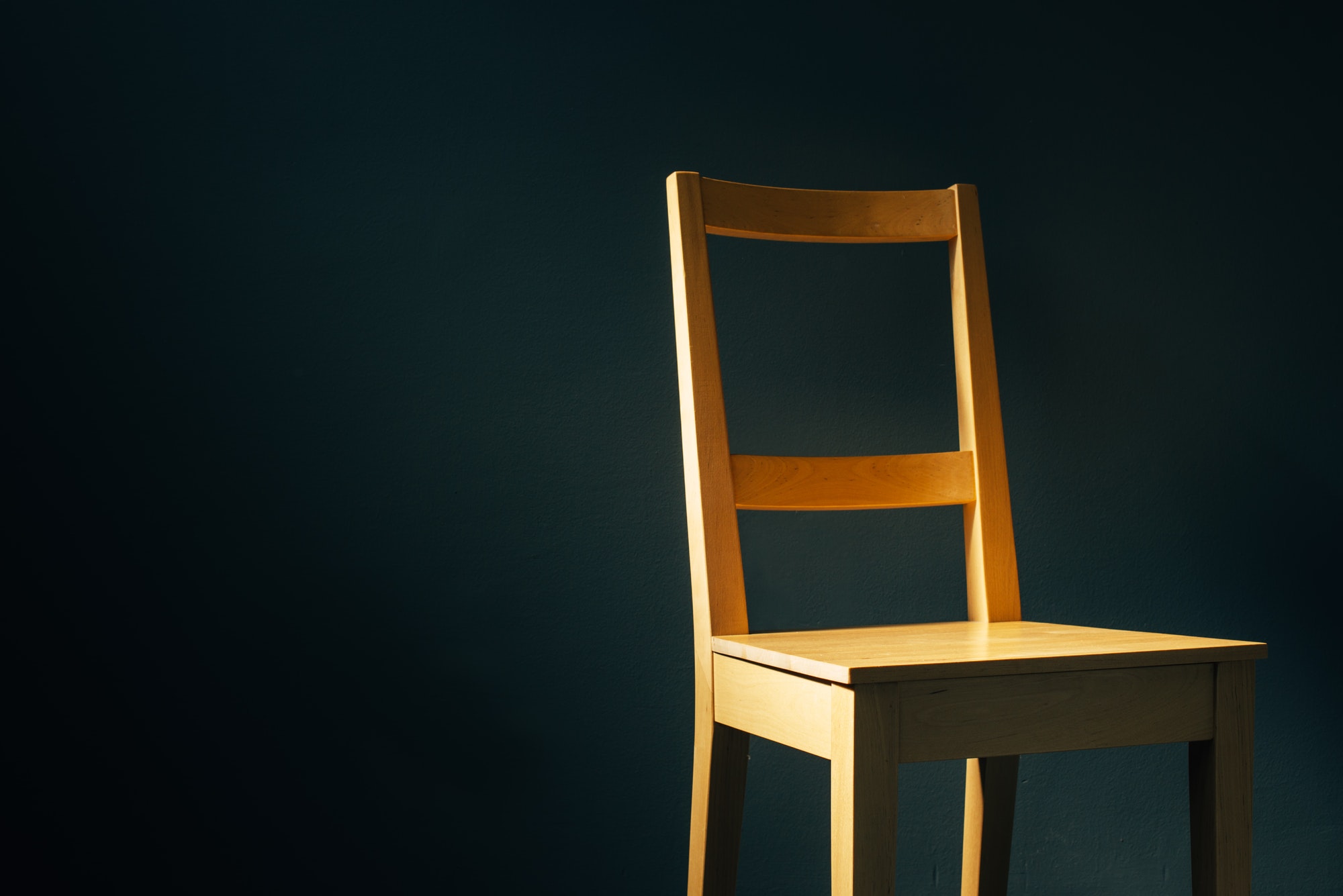 Empty wooden chair in dark room